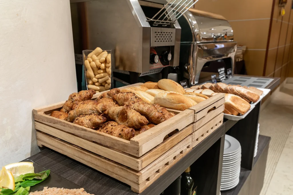 Nell'immagine cesti di croissant e pane fresco o da tostare nel buffet della colazione