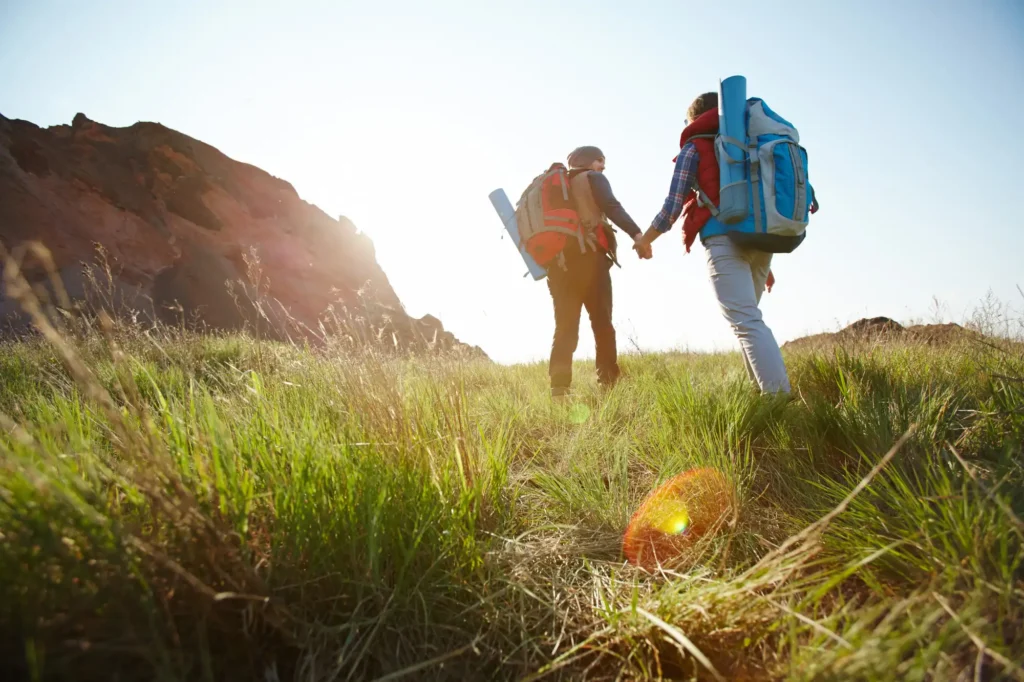 Nell'immagine due persone che fanno trekking sulle montagne vicino a bergamo