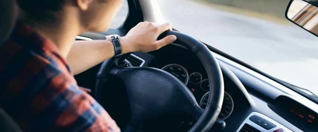 Nell'immagine un uomo alla guida di un auto