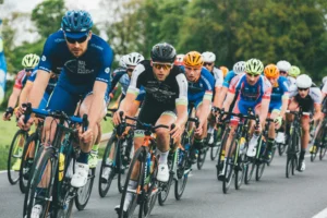 Gruppo di ciclisti intenti a pedalare su una strada con alberi attorno
